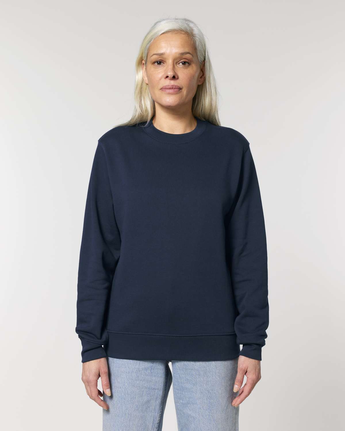 Person wearing a navy blue unisex cotton sweatshirt against a plain background