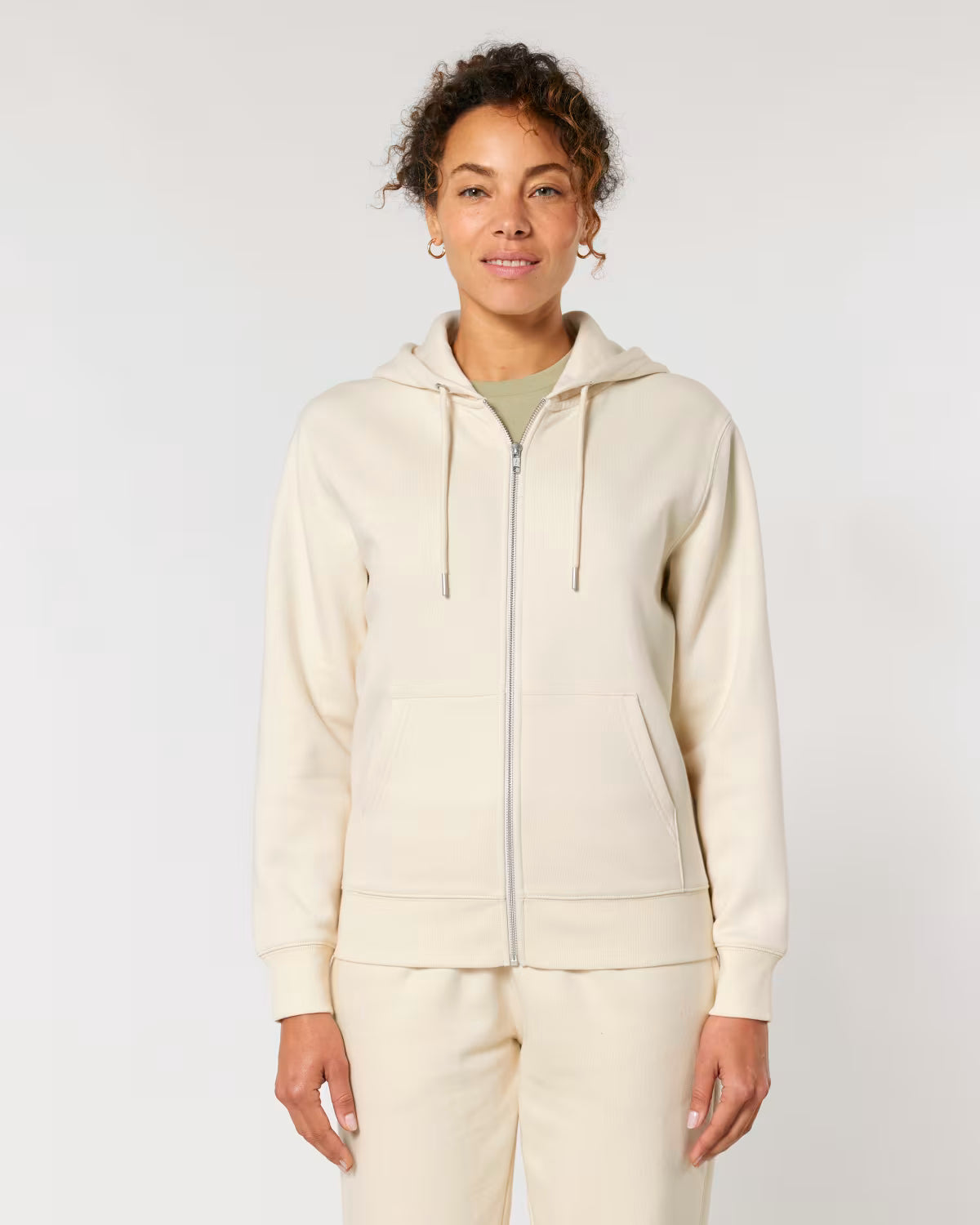 Person wearing a cotton beige hoodie and pants on a white background