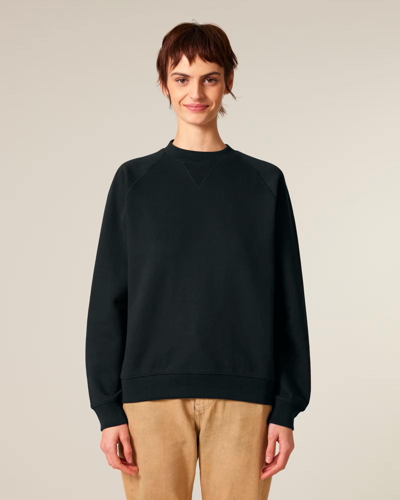 Full body front view of a male model wearing a black cotton sweatshirt in studio