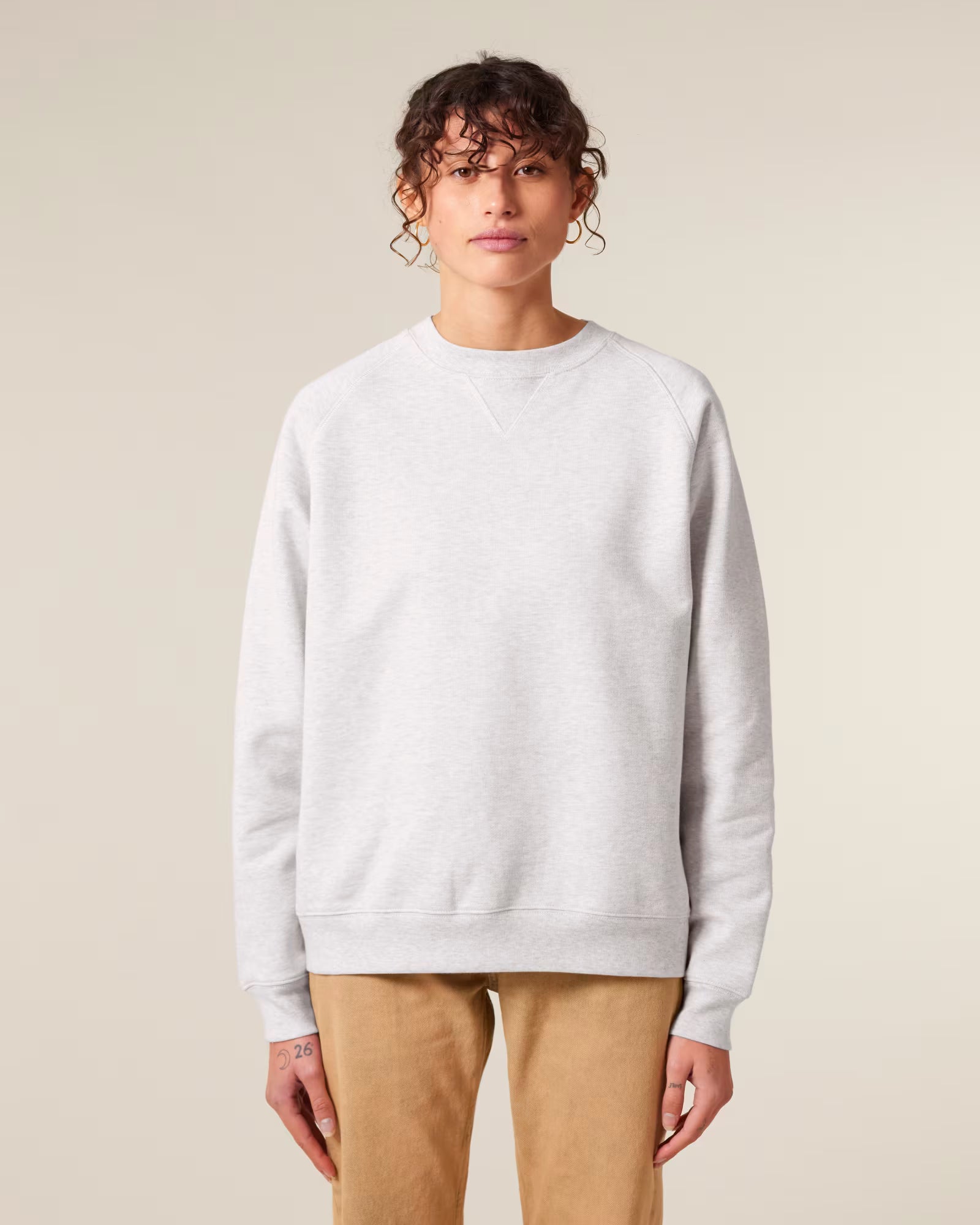 Front view of a male model wearing a white cotton sweatshirt in studio