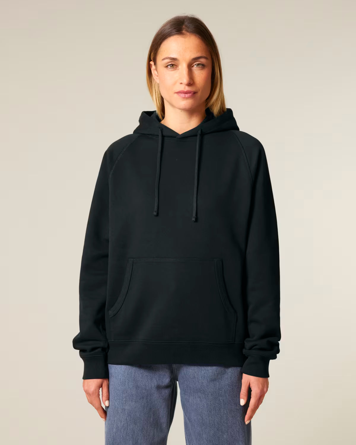 Front view of a female model wearing a black cotton hoodie in studio