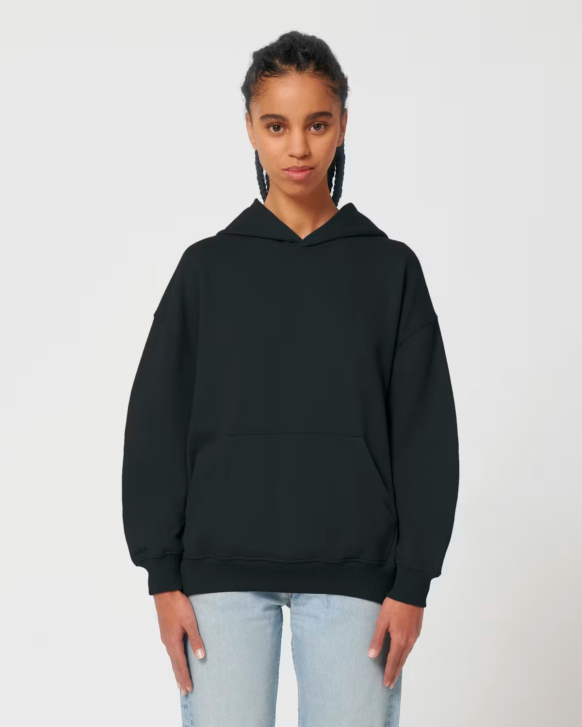 Front view of a male model wearing a black cotton hoodie in studio