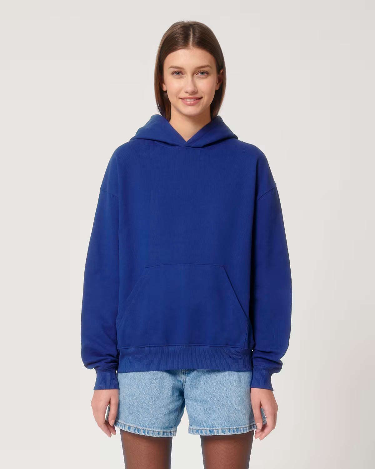 Front view of a female model wearing a royal blue cotton hoodie in studio