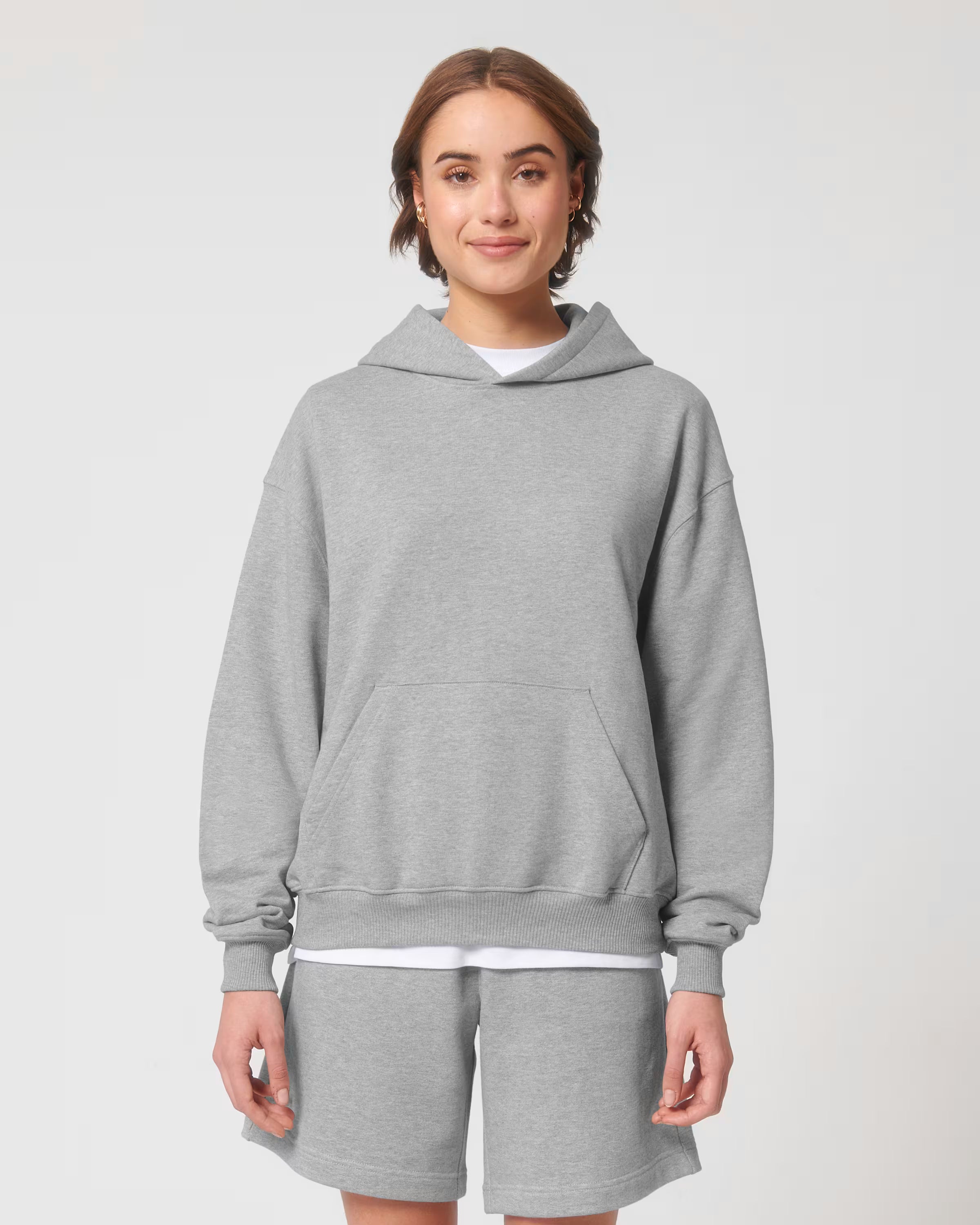 Front view of a female model wearing a light grey cotton hoodie in studio