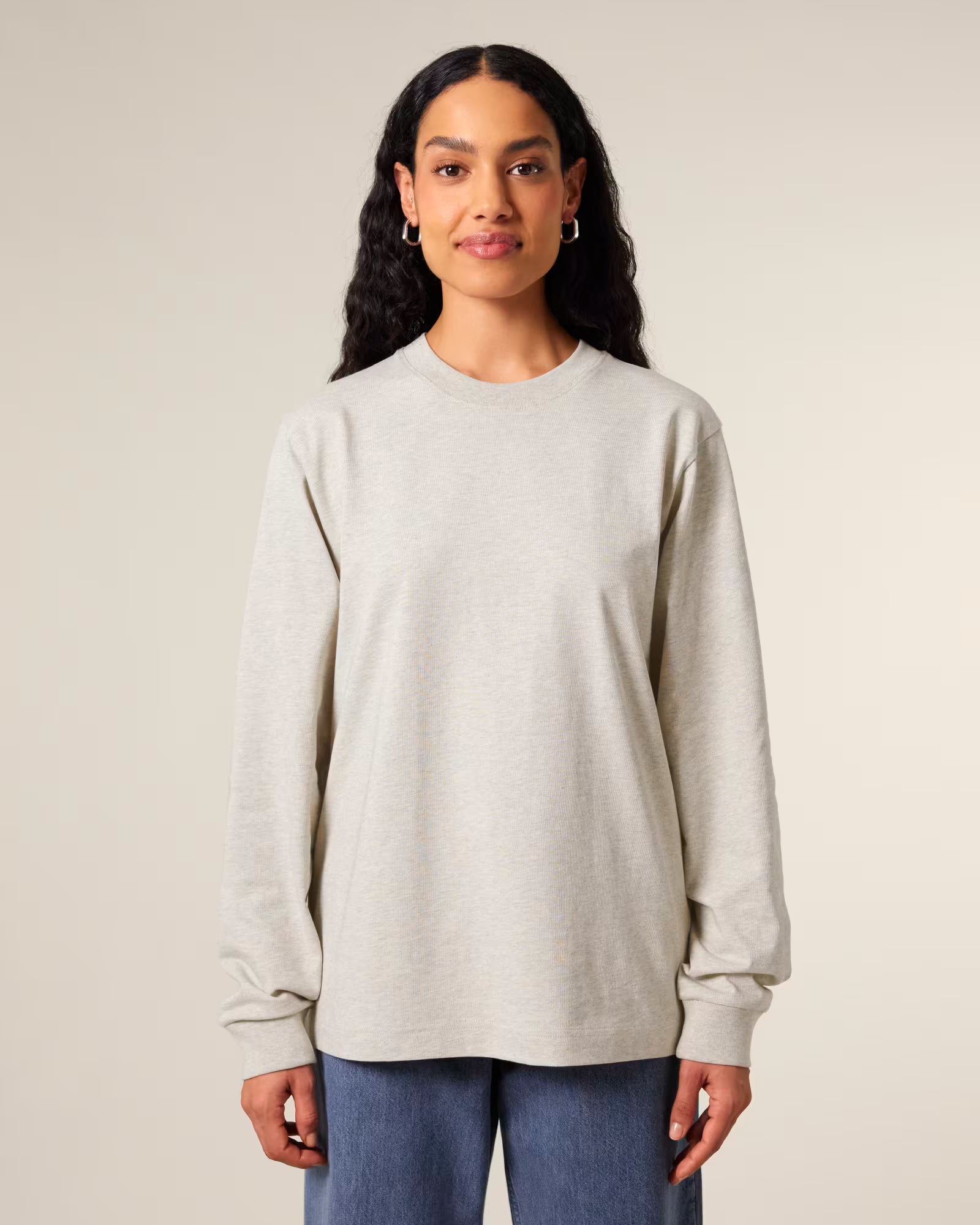 Front view of a female model wearing a light beige cotton long sleeve t-shirt in studio