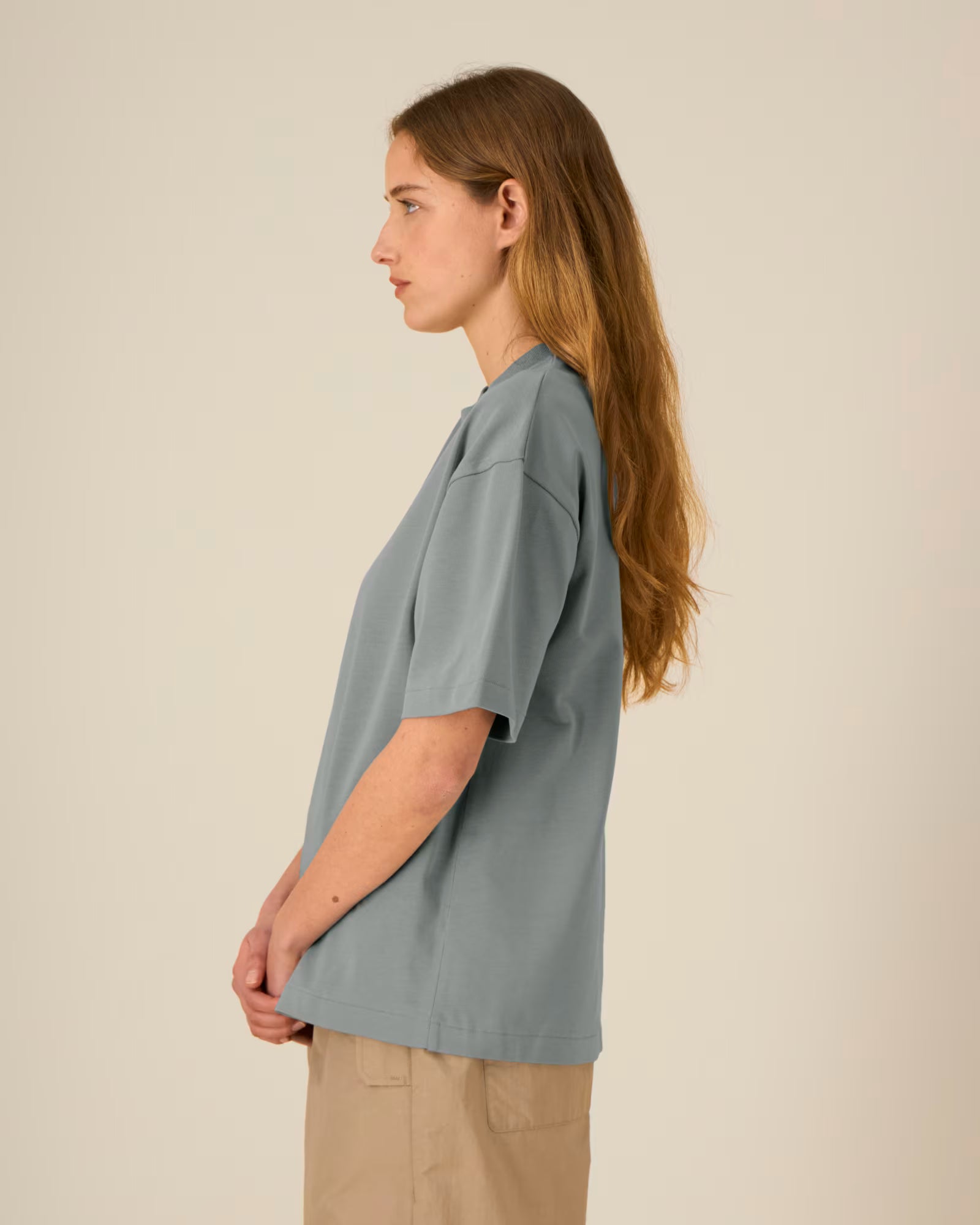 Side view of a female model wearing a light blue cotton t-shirt in studio