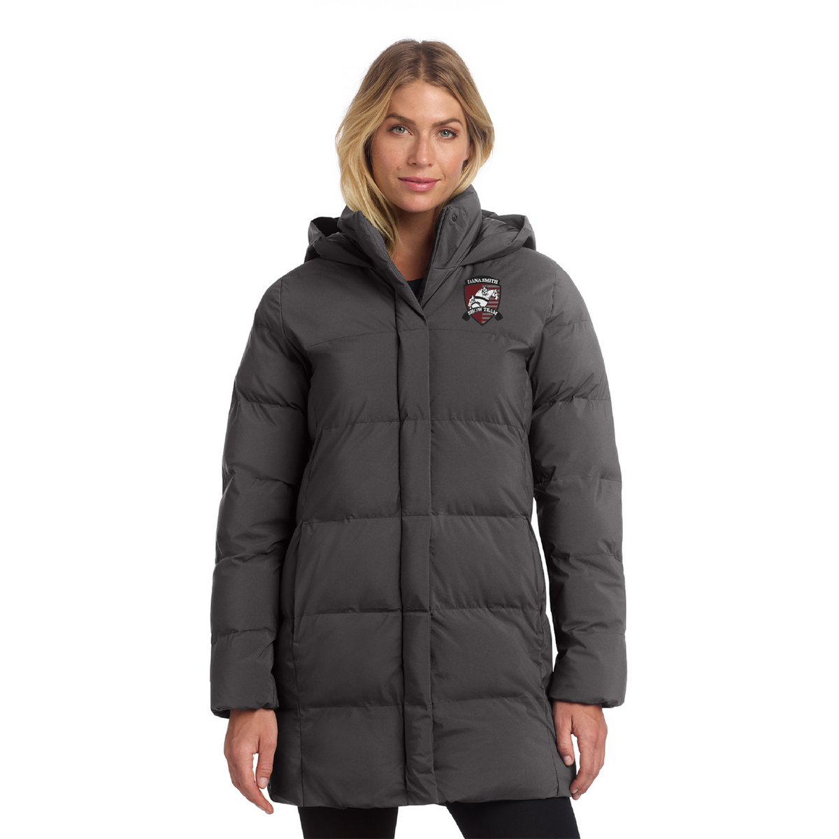 A woman modeling a dark gray hooded puffer coat with a vertical zip closure and a small red, white, and black logo patch on the left chest, set against a plain white background.