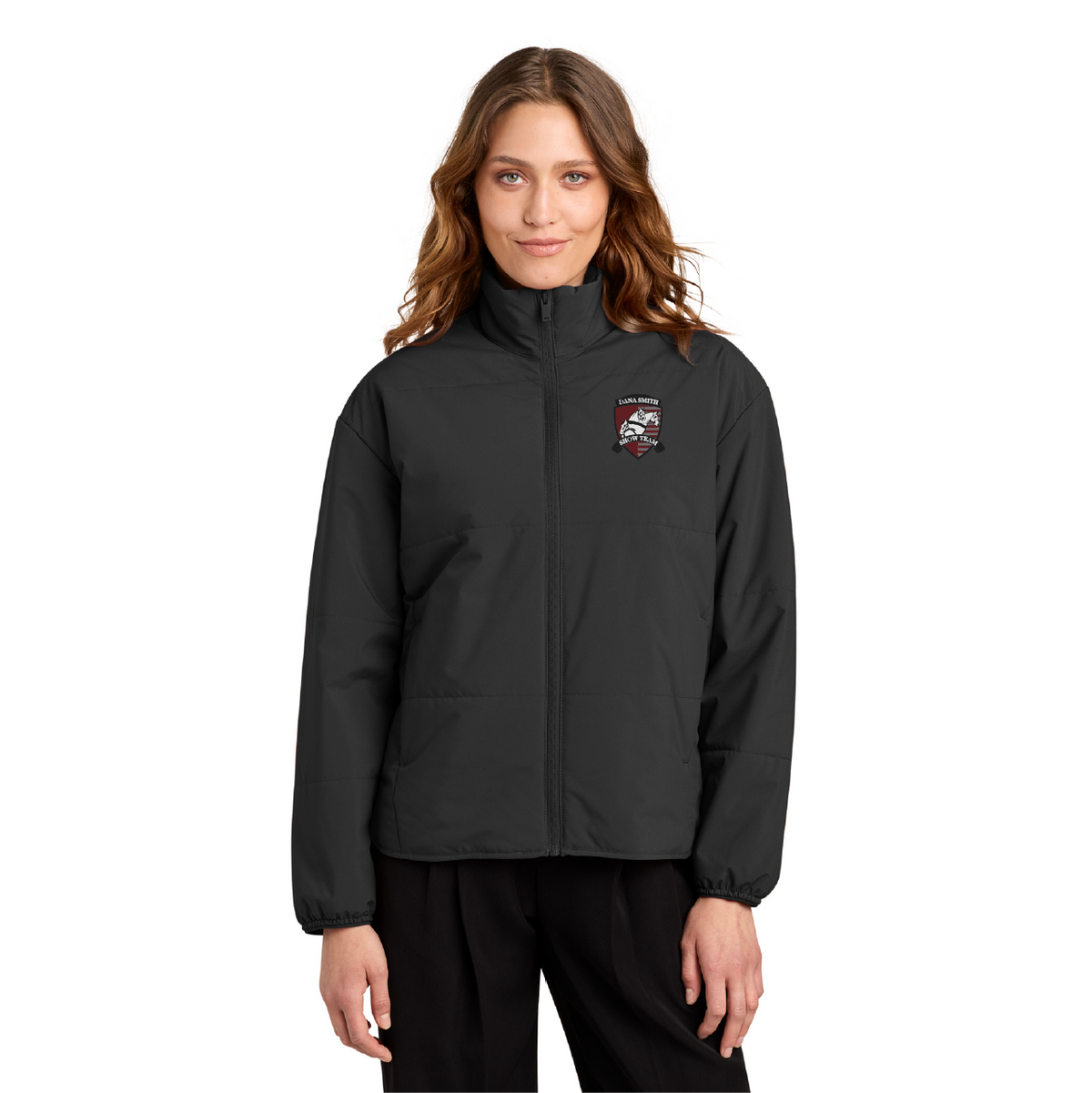 A woman modeling a black zip-up jacket with a small embroidered logo on the left chest, set against a plain white background.