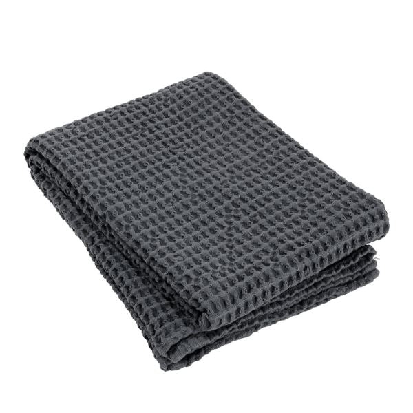 Folded dark gray unisex cotton waffle-textured blanket on a white background