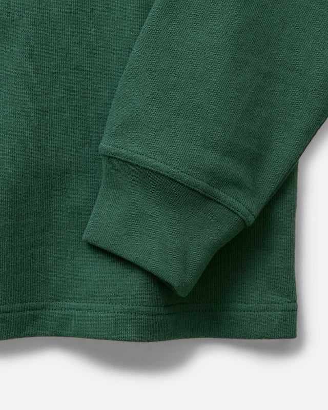 Close-up of a green long-sleeve shirt with rolled-up sleeve on a white background