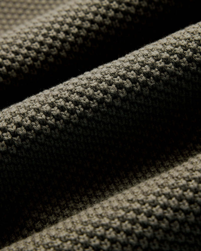 Close-up of textured green fabric with a subtle pattern