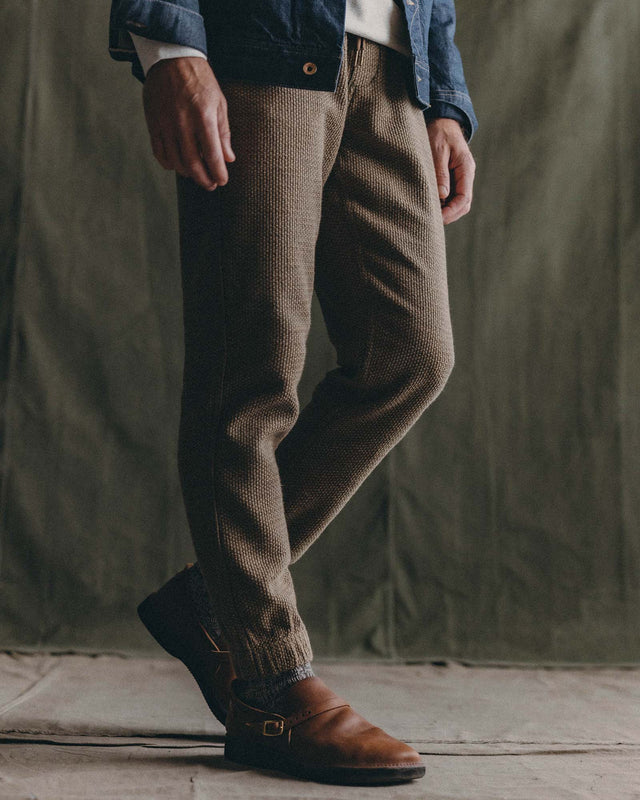 Olive green men’s jogger pants styled with brown boots